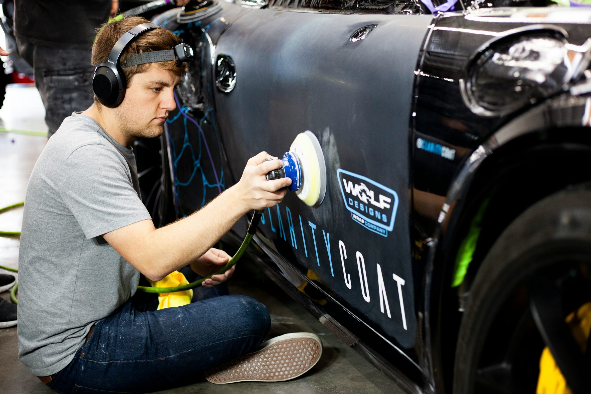 a man is painting a car with a spray gun